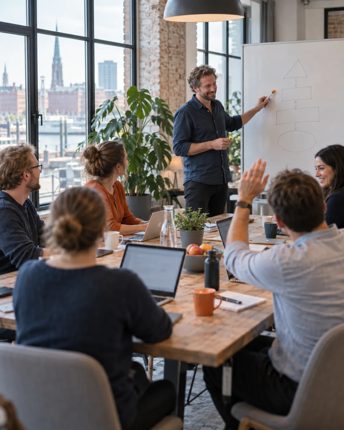 Relaxed training session at a large table, a trainer explaining at the whiteboard